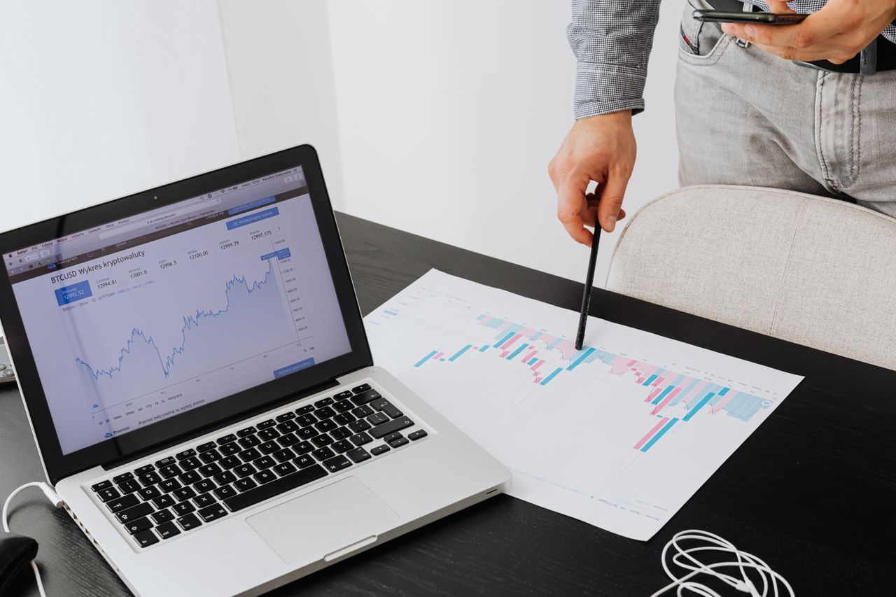 Personne analysant des données de cryptomonnaie sur un ordinateur portable, mettant en avant des informations financières.